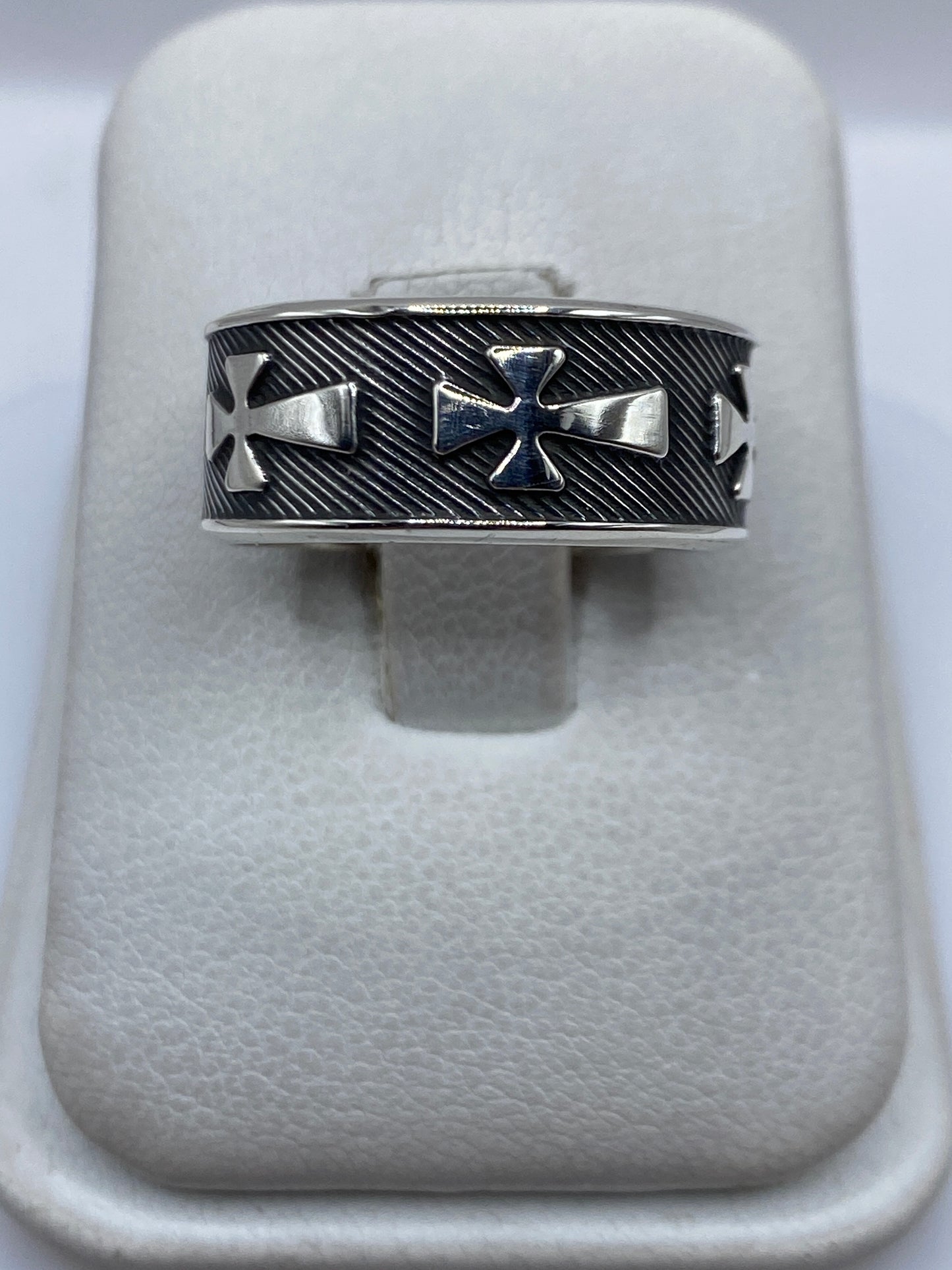 Anillo de plata con cruces religiosas en relieve, visto desde arriba