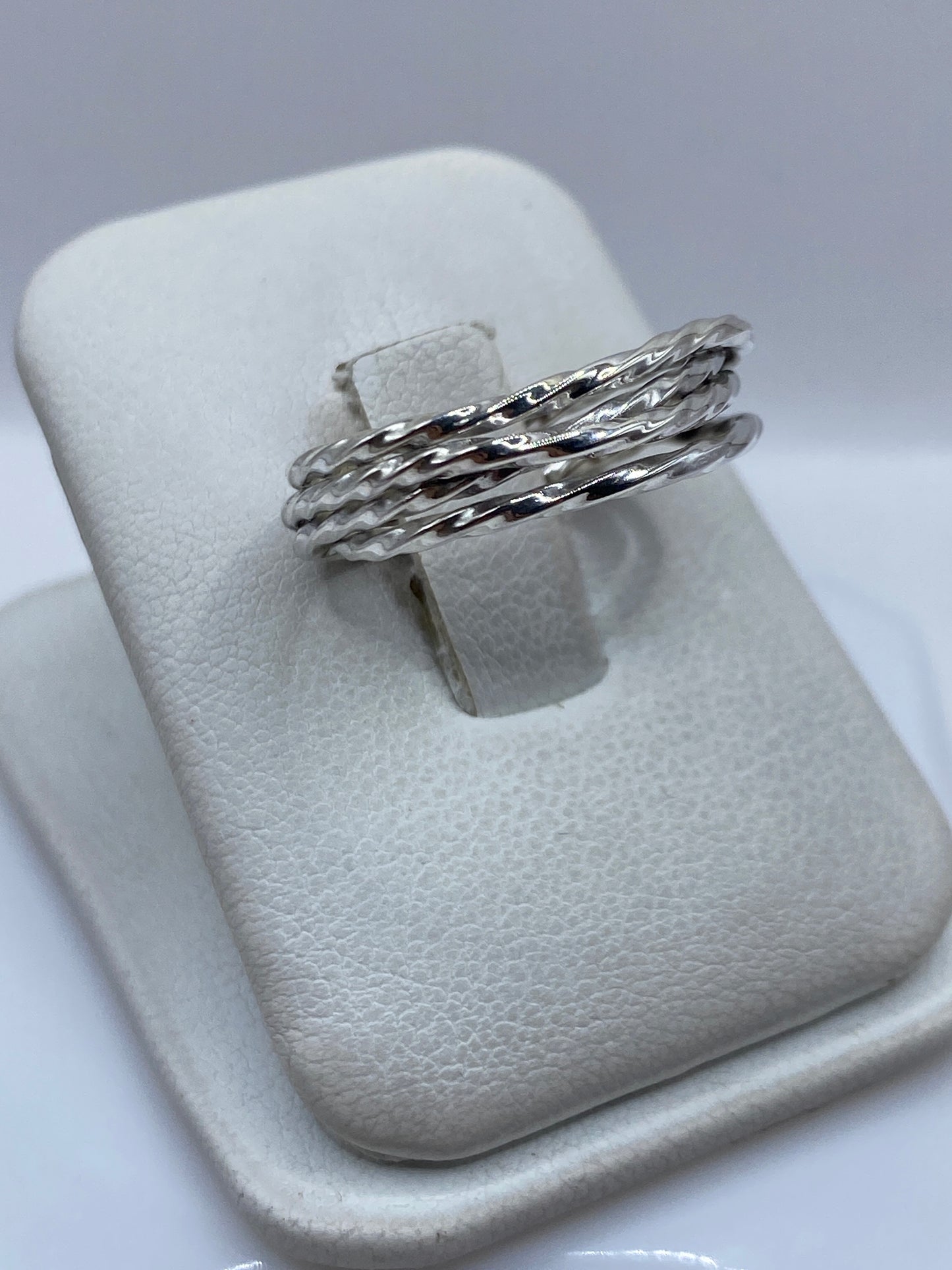 Detalle lateral del anillo mostrando las bandas trenzadas y el pulido brillante