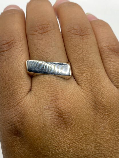 Anillo de plata sobre fondo blanco con escala de peso 7.9 gramos