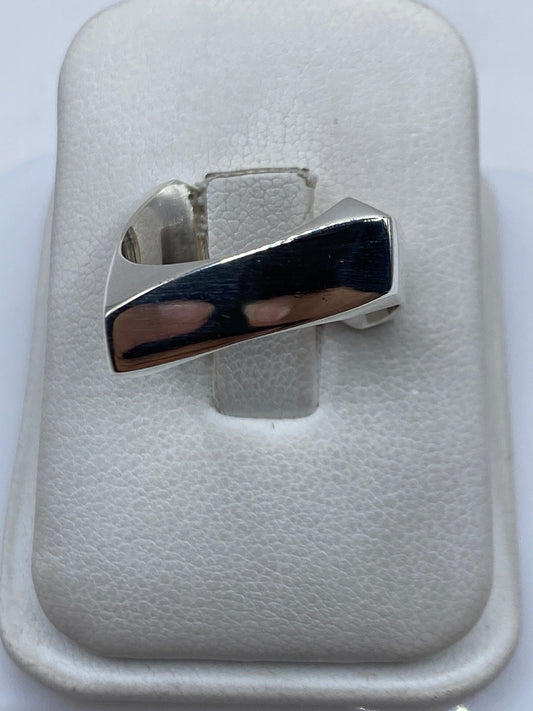 Anillo de plata cartoneado con diseño geométrico moderno en la mano de una persona