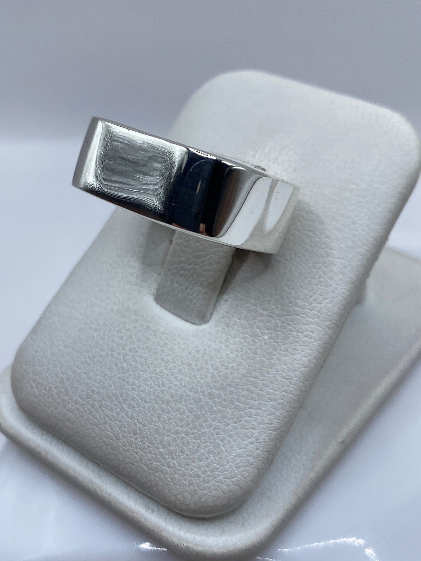Anillo de plata en cartoneado de Taxco en la mano, mostrando volumen y peso