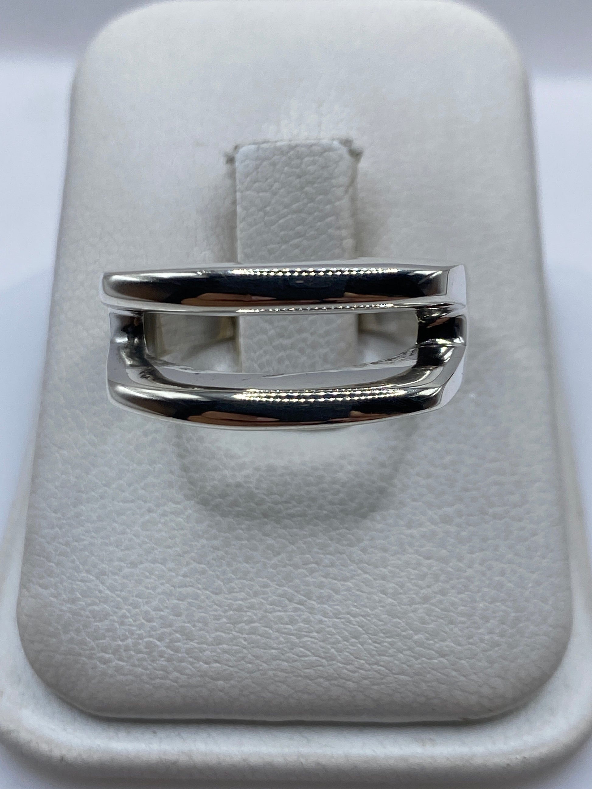 Anillo de plata con técnica de calado minimalista en la mano de una mujer