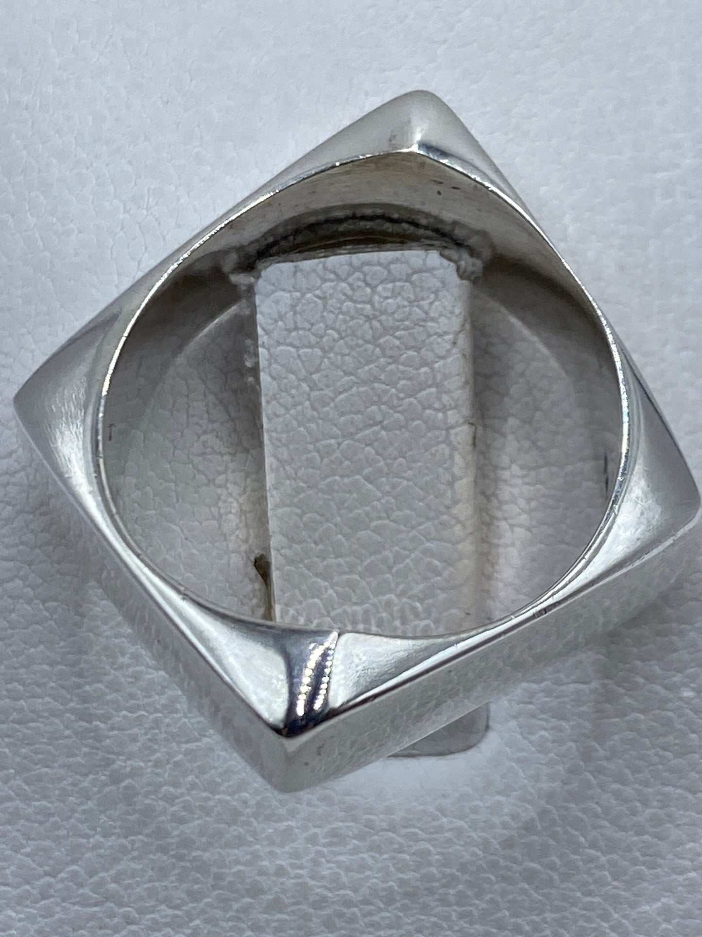 Detalle del anillo puesto en mano masculina, diseño unisex