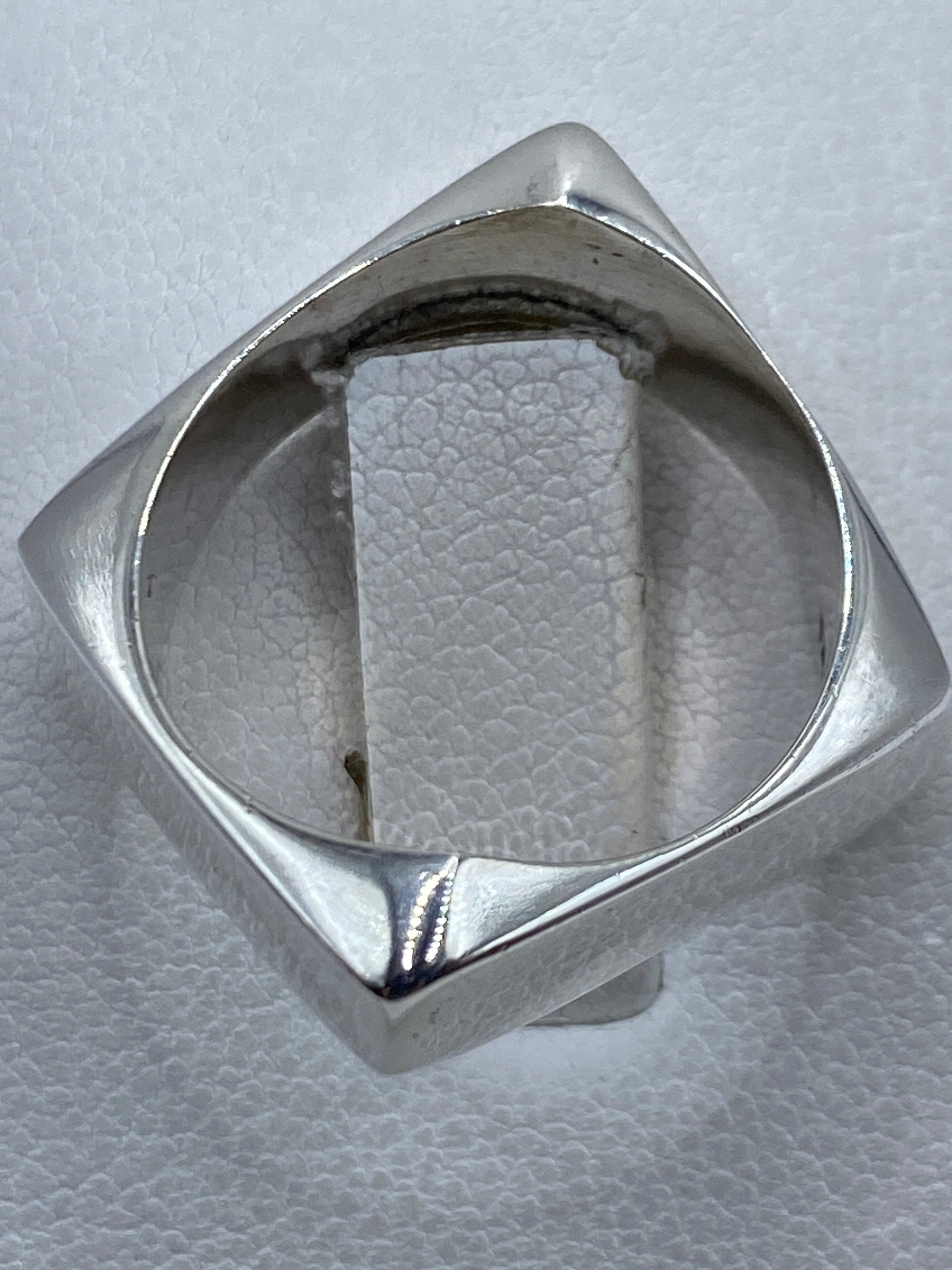Detalle del anillo puesto en mano masculina, diseño unisex