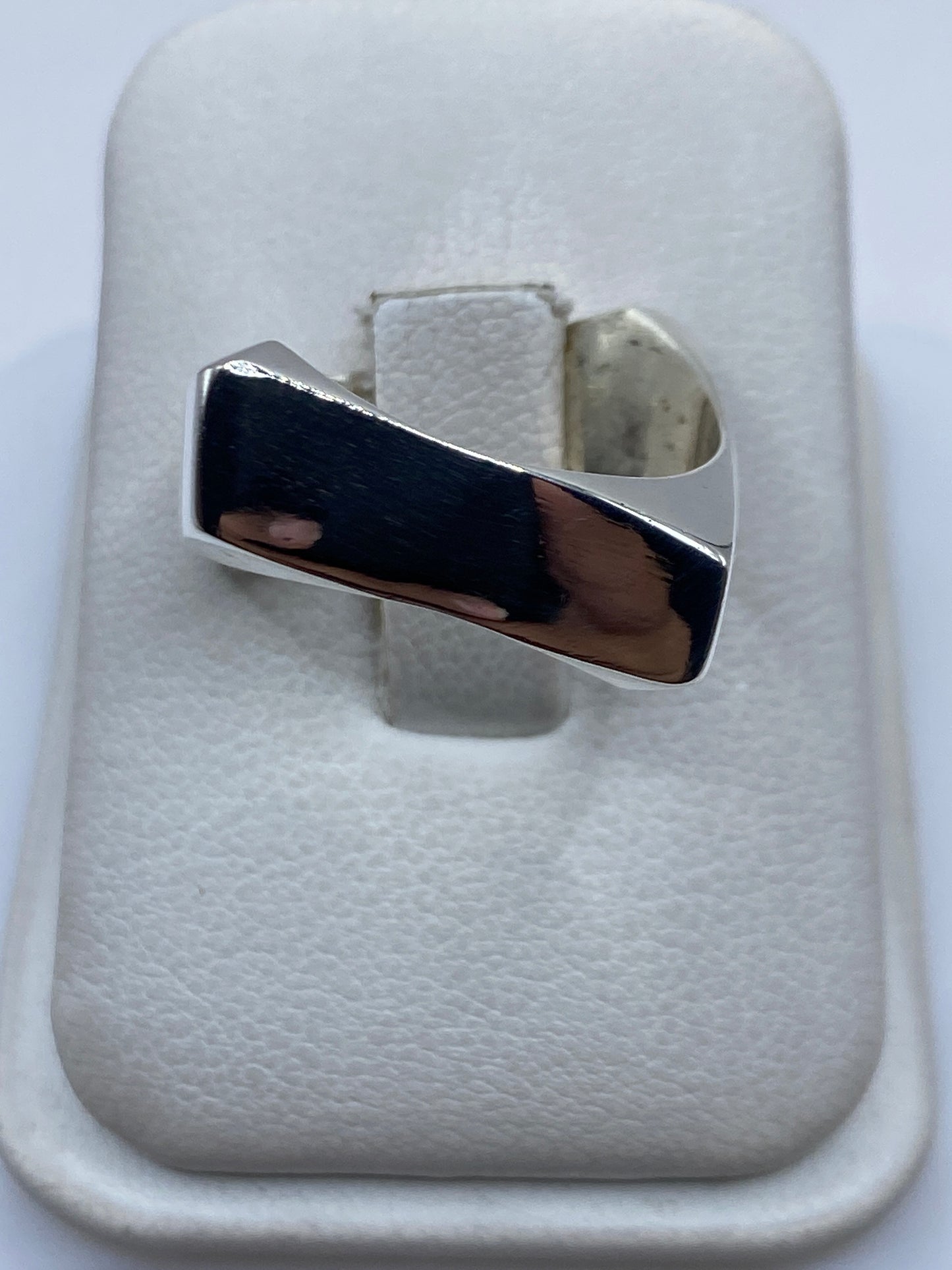 Anillo de plata cartoneado minimalista sobre fondo blanco mostrando el volumen 3D