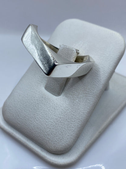 Detalle del anillo cartoneado en la mano, vista lateral del acabado pulido