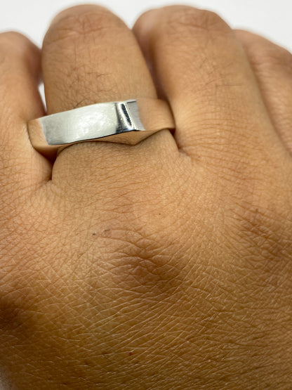 Anillo de plata cartoneado sobre mesa gris, imagen de escala de peso 8.3 gramos