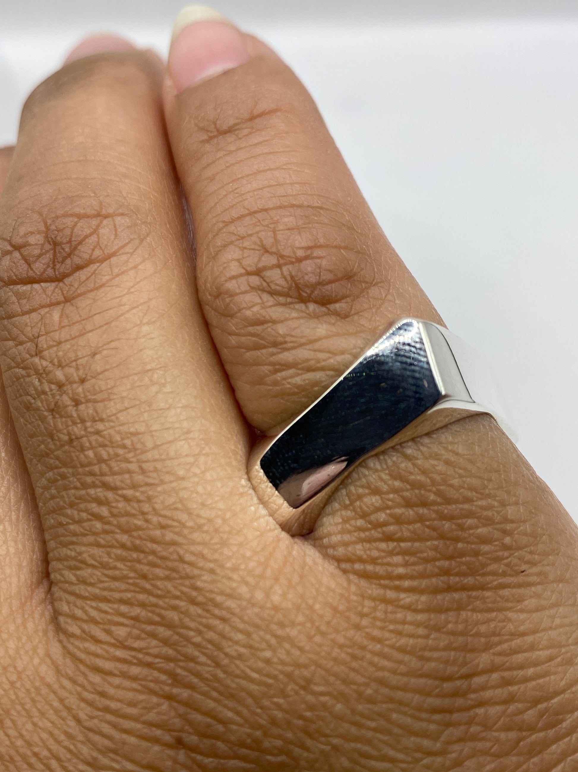 Anillo puesto en dedo, mostrando el brillo y presencia del diseño unisex