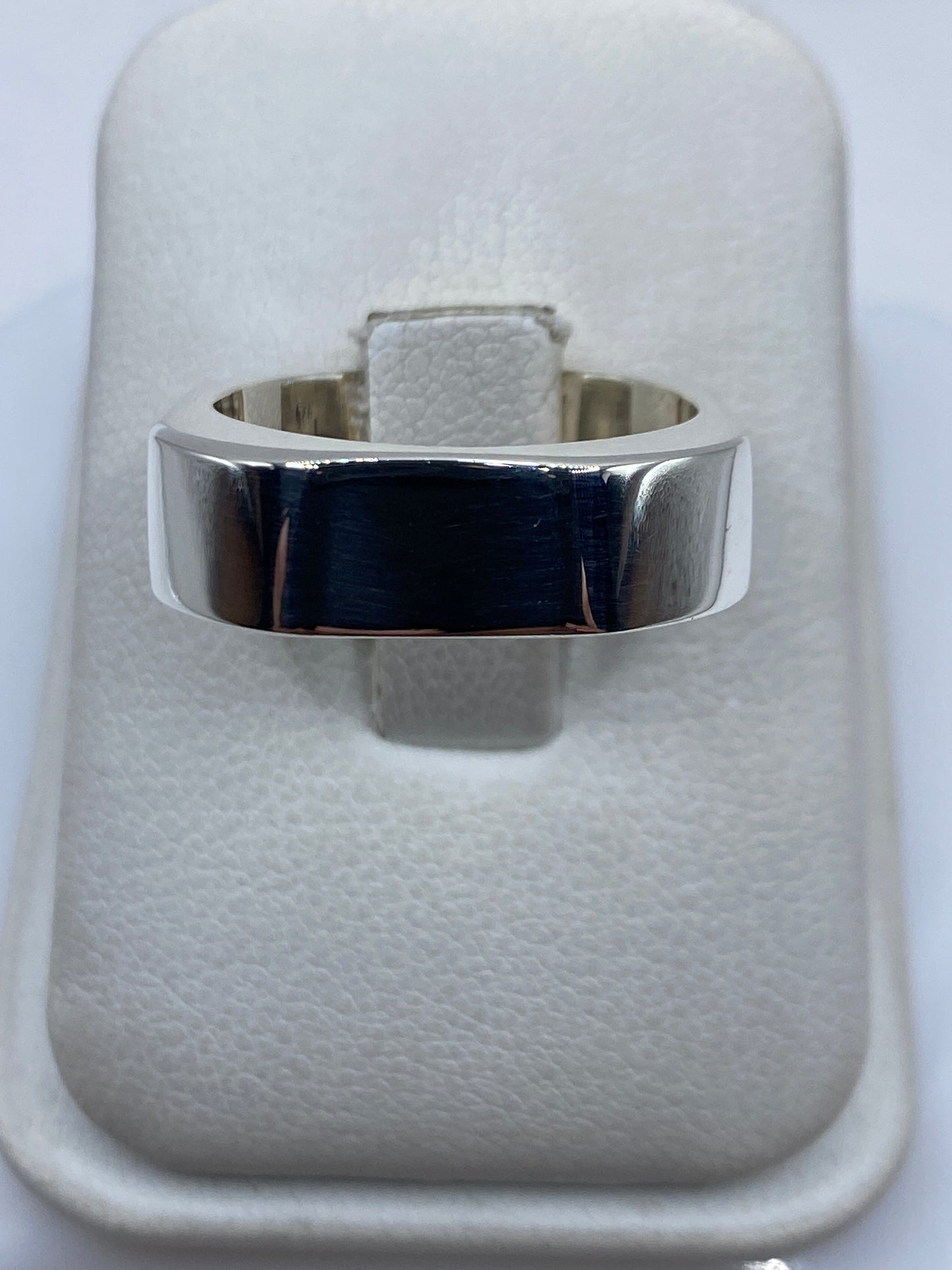 Anillo de plata cartoneado geométrico en talla 8, vista superior sobre estuche blanco