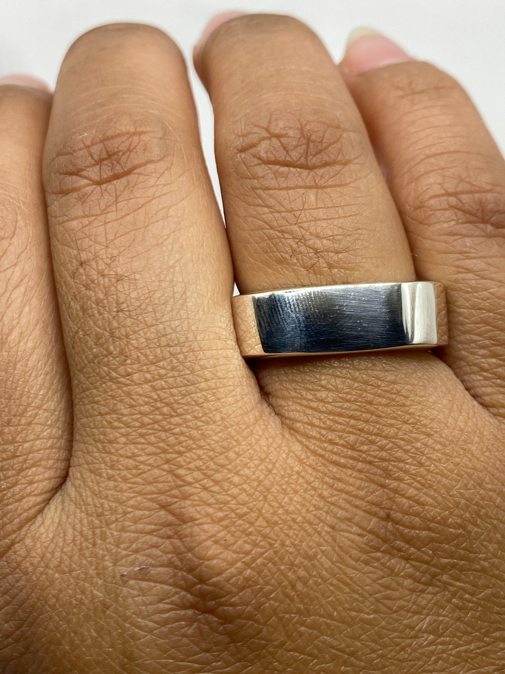 Anillo sobre fondo gris mostrando el sello .925 interior y la forma geométrica