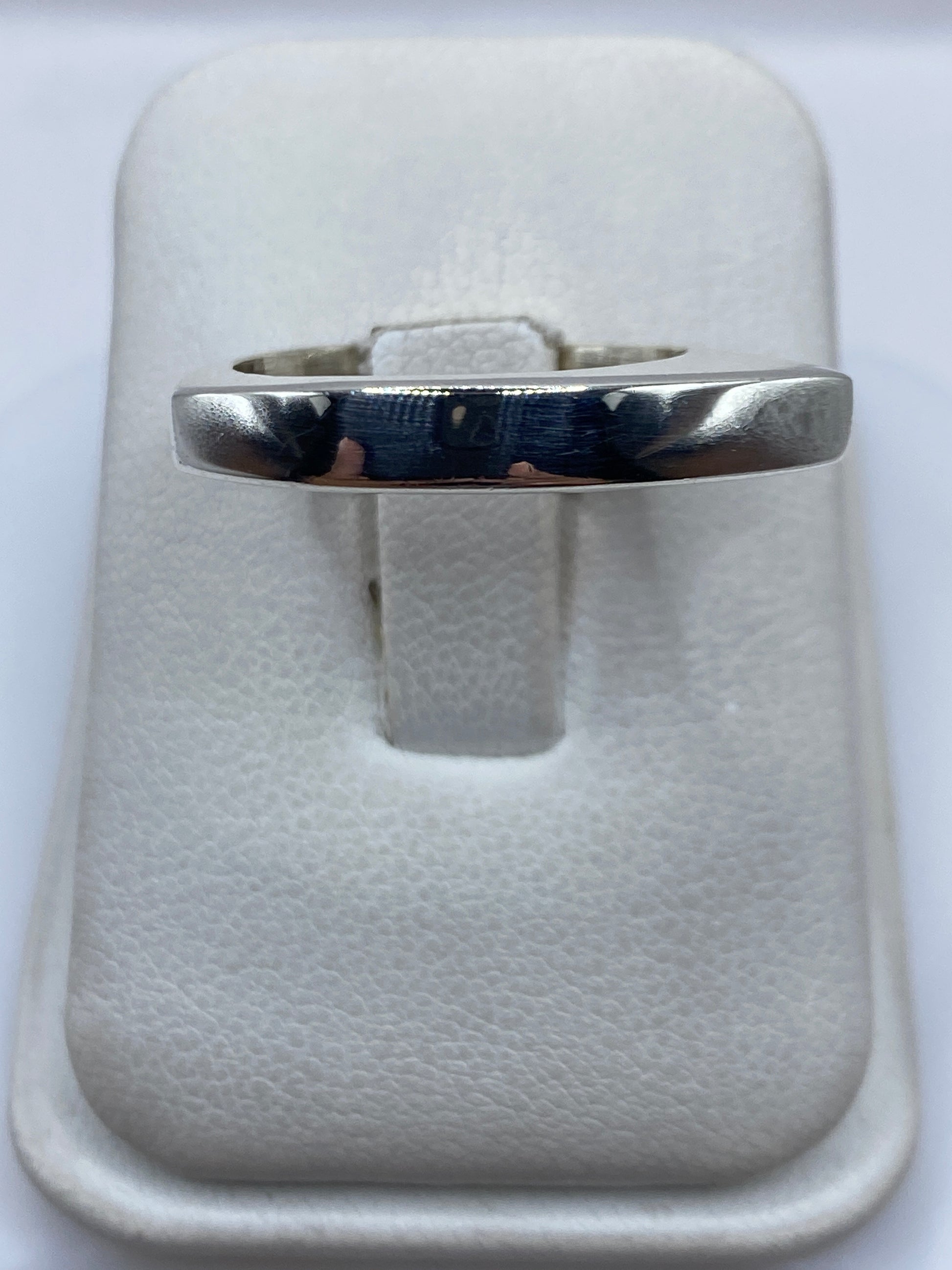 Anillo de plata cartoneado minimalista en mano, mostrando el volumen 3D