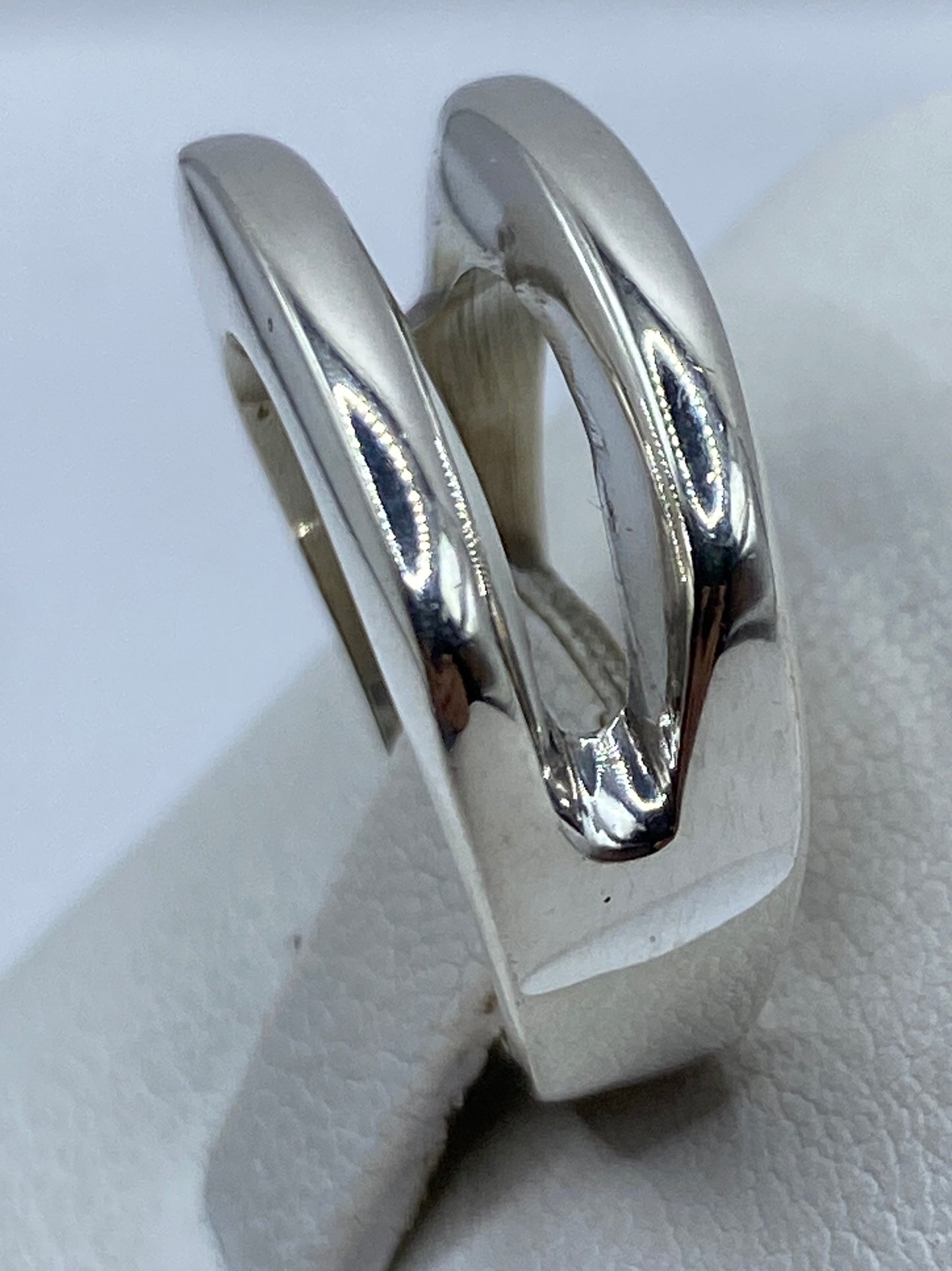 Detalle del anillo en la mano mostrando el pulido brillante y la geometría