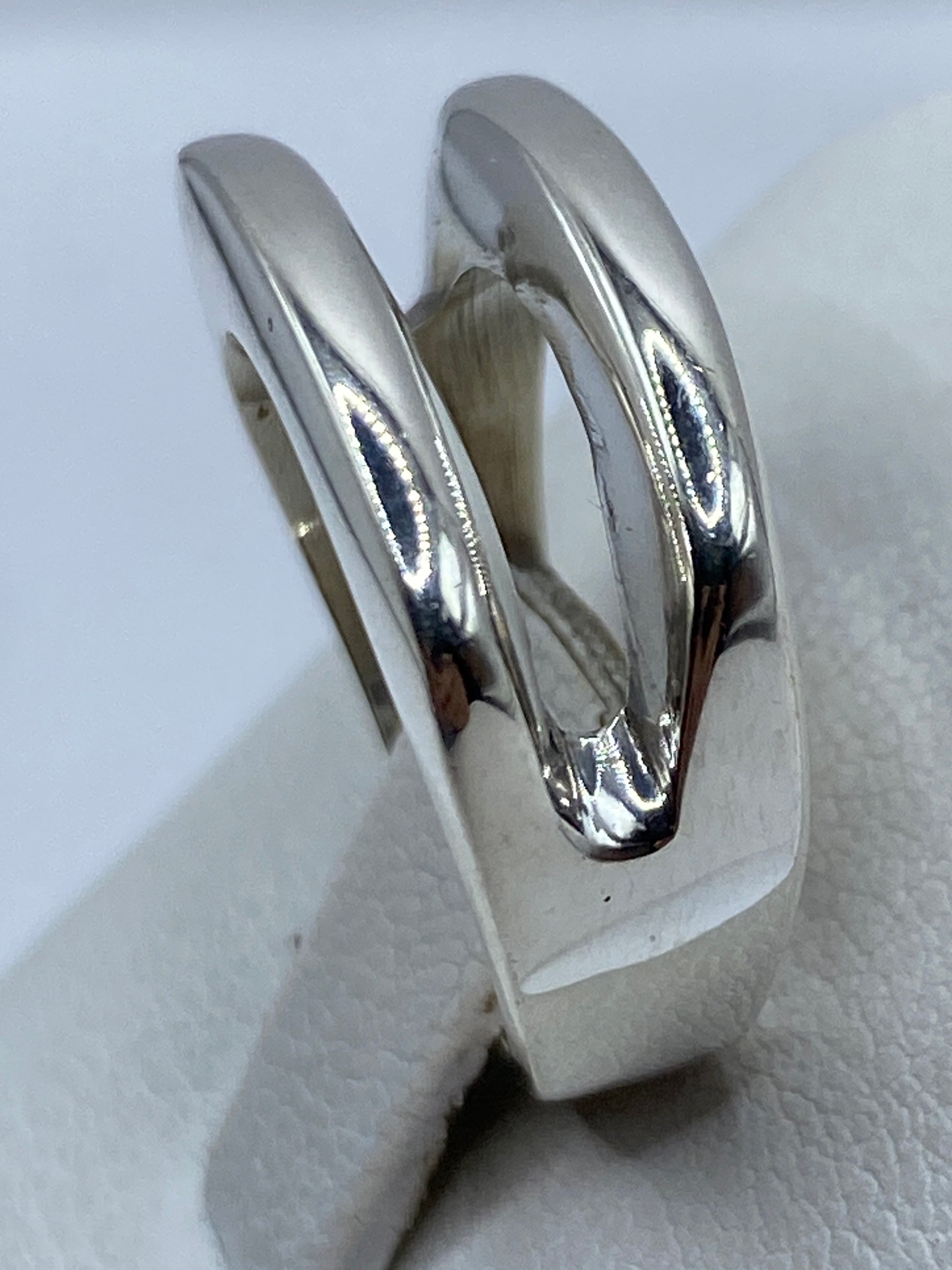 Detalle del anillo en la mano mostrando el pulido brillante y la geometría