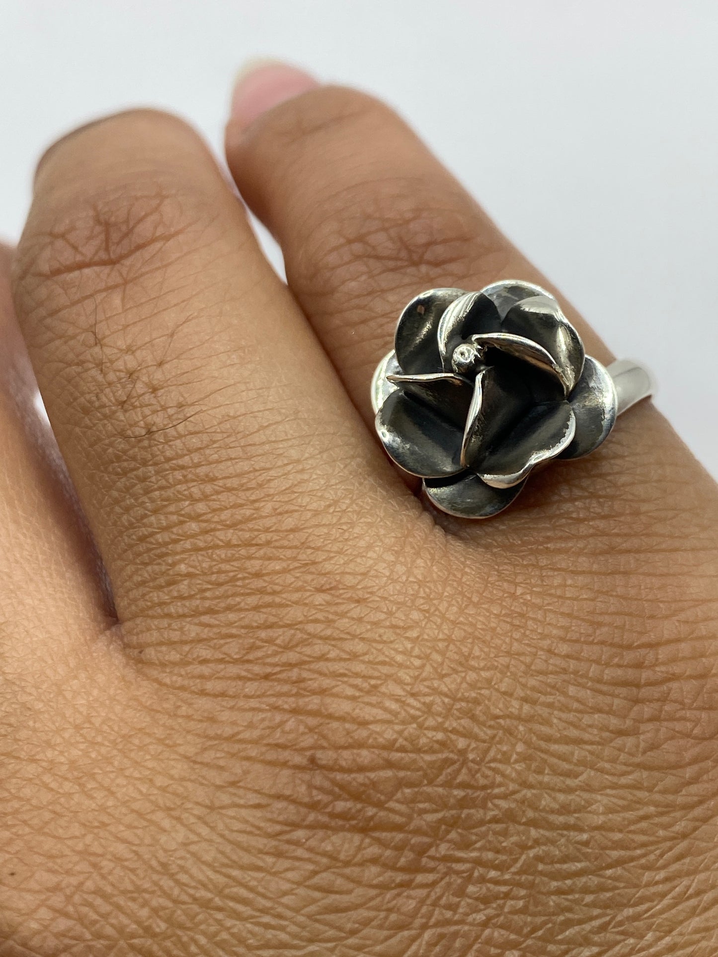 Anillo en dedo mostrando el brillo y el acabado pulido de la rosa