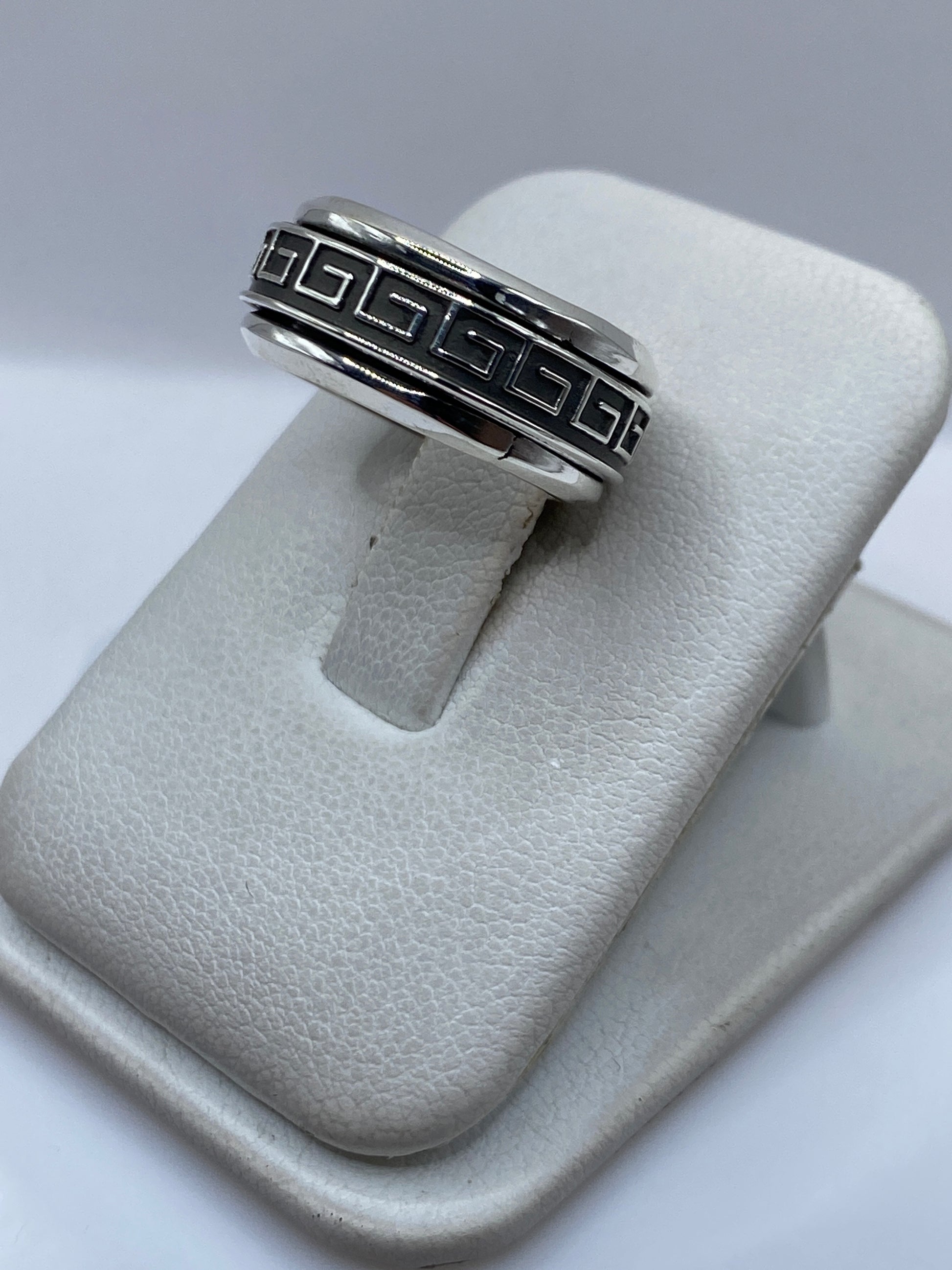 Vista frontal del anillo mostrando la banda exterior giratoria y el diseño de greca