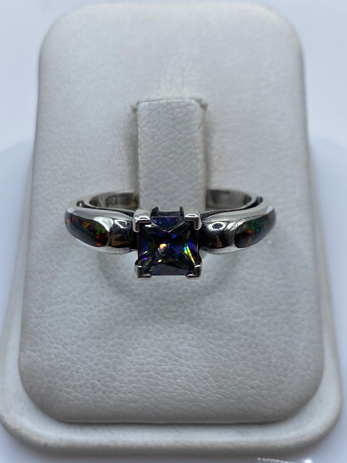 Anillo de plata .950 con ópalo de fuego multicolor visto de frente mostrando el juego de luces verdes, amarillas y rojas