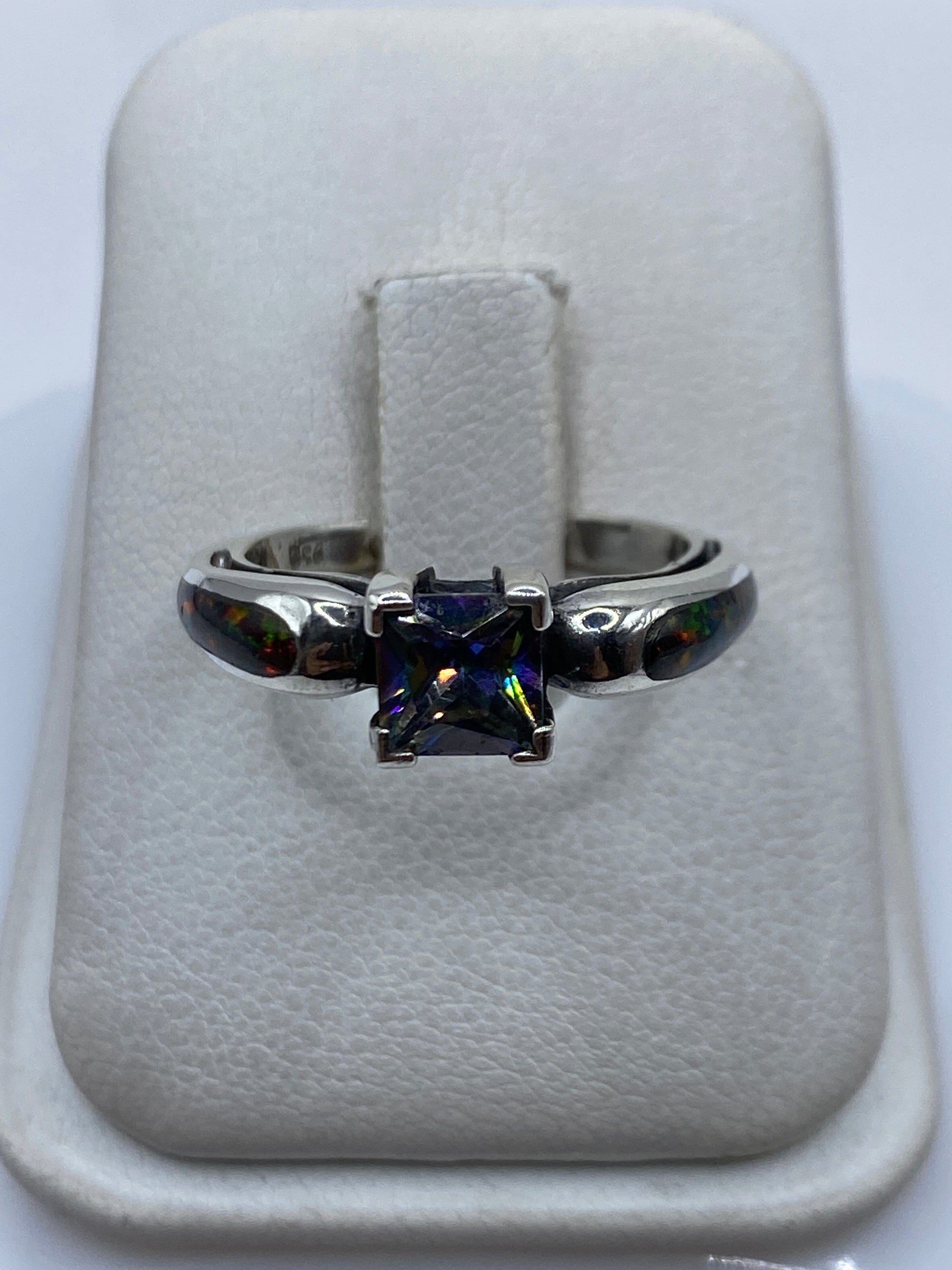 Anillo de plata .950 con ópalo de fuego multicolor visto de frente mostrando el juego de luces verdes, amarillas y rojas