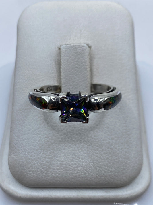 Anillo de plata .950 con ópalo de fuego multicolor visto de frente mostrando el juego de luces verdes, amarillas y rojas