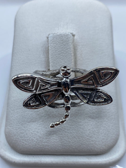 Anillo de plata libélula con alas abiertas y detalle étnico en la mano de una mujer