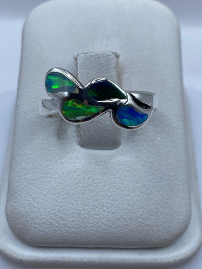 Anillo de plata .925 con ópalo de fuego multicolor en tono azul y verde sobre cojín blanco