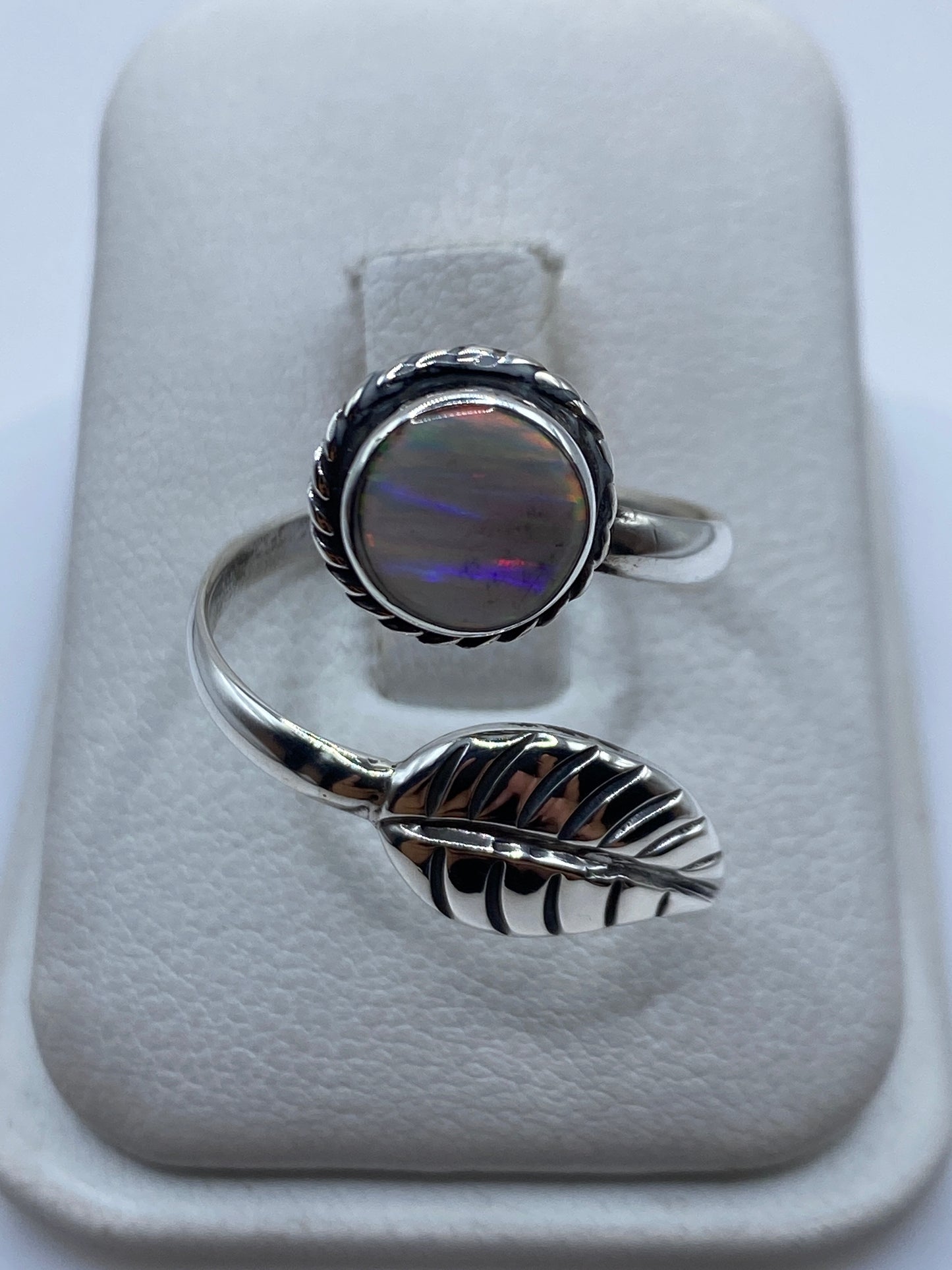 Anillo de plata ajustable con ópalo de fuego multicolor iridiscente mostrando colores amarillos y rojos