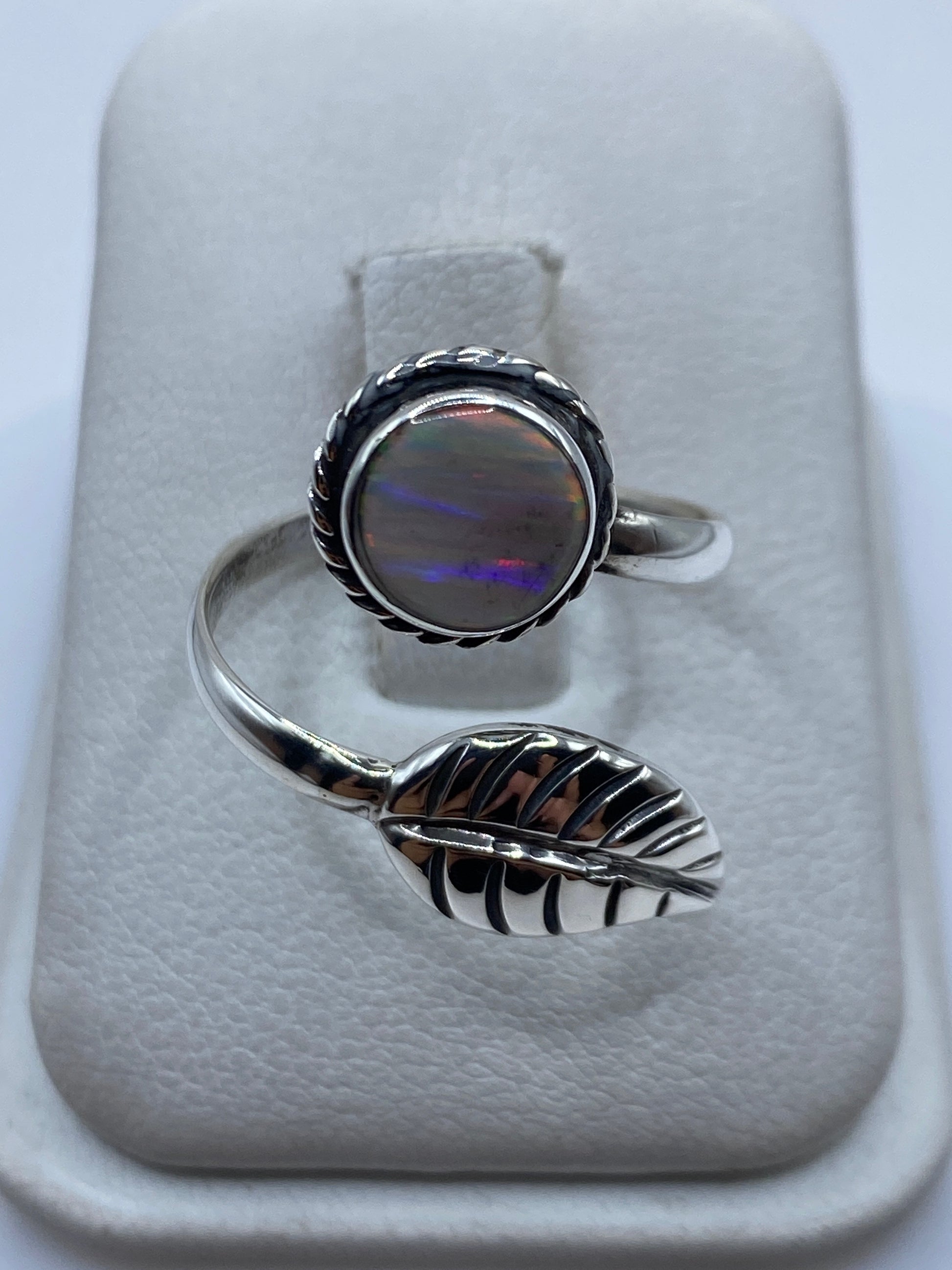 Anillo de plata ajustable con ópalo de fuego multicolor iridiscente mostrando colores amarillos y rojos