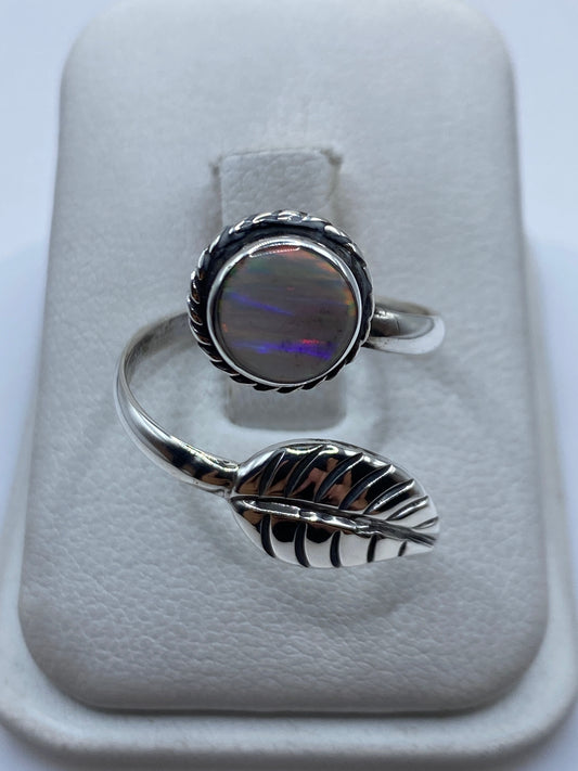 Anillo de plata ajustable con ópalo de fuego multicolor iridiscente mostrando colores amarillos y rojos