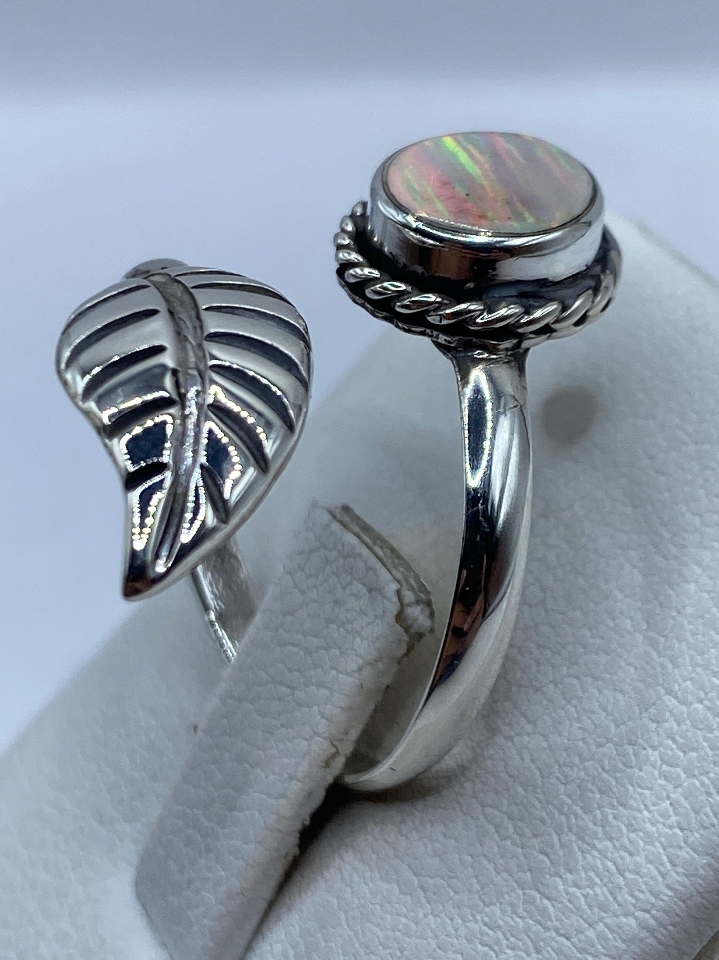Anillo ajustable de plata .925 con ópalo de fuego en la mano de una mujer