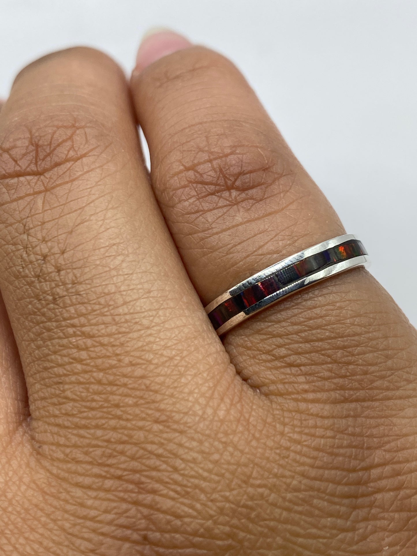 Anillo en el dedo mostrando la ligereza y brillo del ópalo multicolor