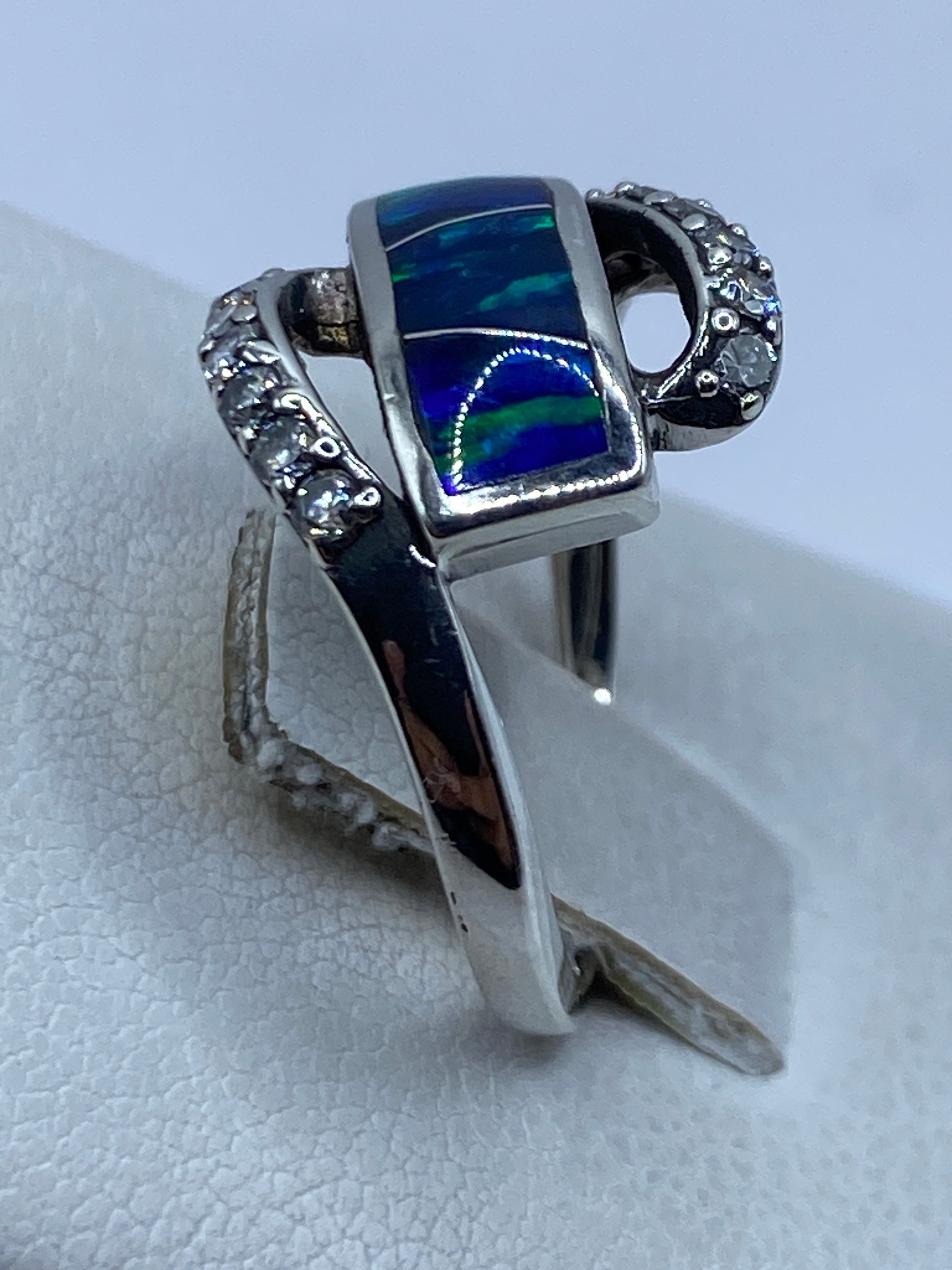 Anillo de ópalo de fuego en la mano, mostrando los tonos azules de la gema