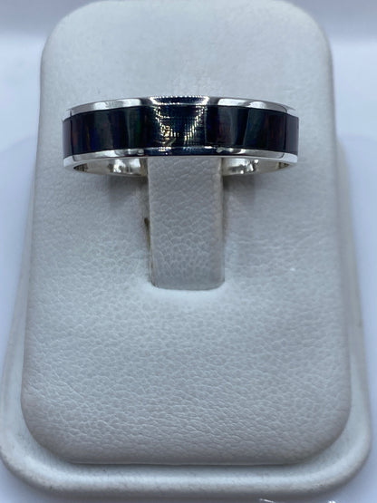Anillo de plata .950 con ópalo de fuego multicolor en dedos de una mano sobre fondo blanco