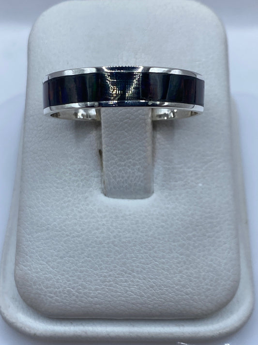 Anillo de plata .950 con ópalo de fuego multicolor en dedos de una mano sobre fondo blanco