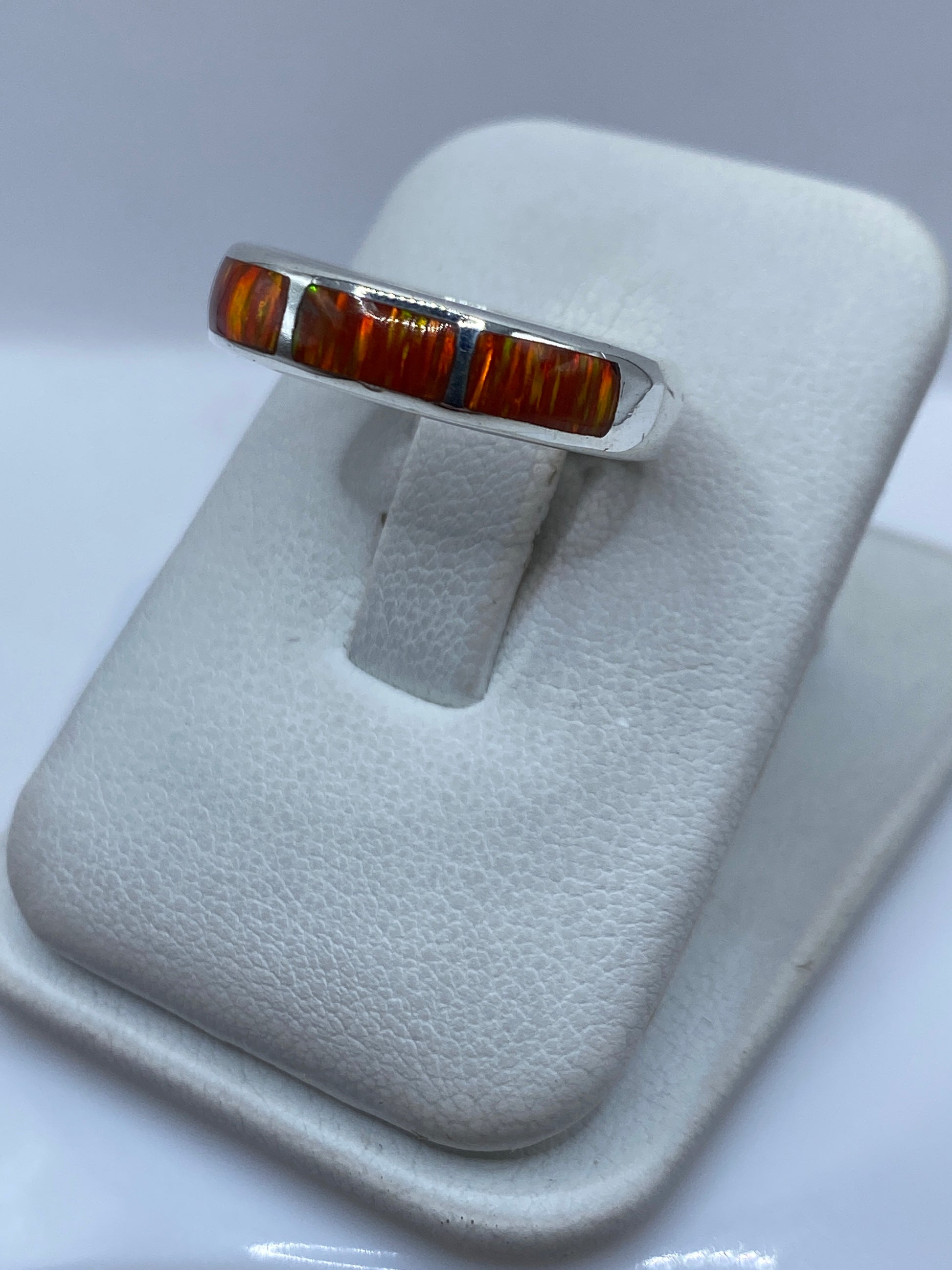 Vista lateral del anillo mostrando el engaste a mano del ópalo naranja en plata pura
