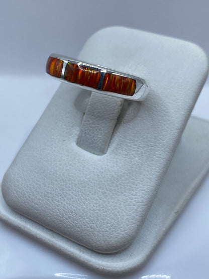 Vista lateral del anillo mostrando el engaste a mano del ópalo naranja en plata pura