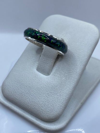 Detalle lateral del anillo mostrando el ópalo de fuego con reflejos verdes y azules