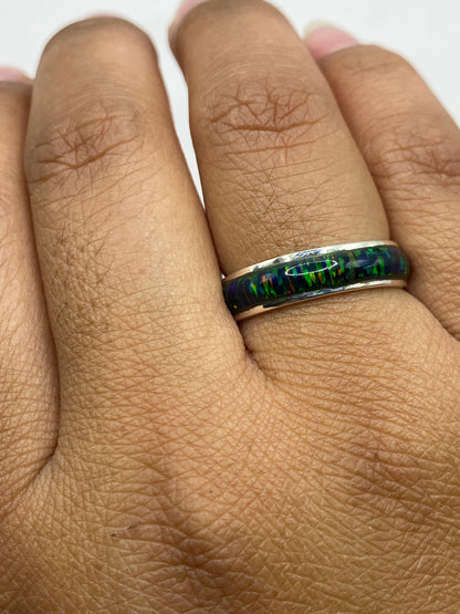 Anillo en mano mostrando cómo el ópalo cambia de color según la luz