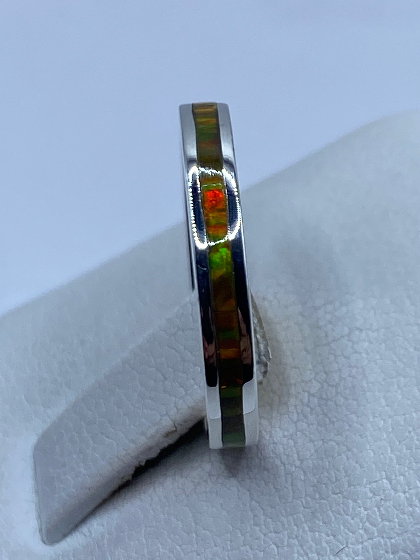 Anillo de plata .950 en la mano mostrando el brillo multicolor del ópalo
