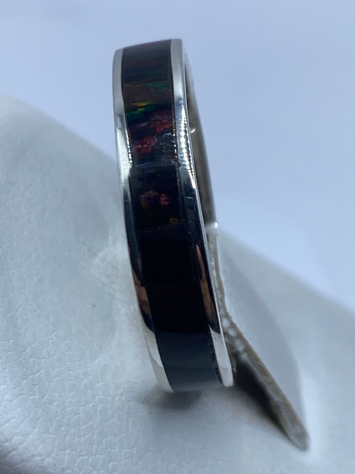 Anillo en plata .950 visto de lado, mostrando la incrustación delicada de la piedra