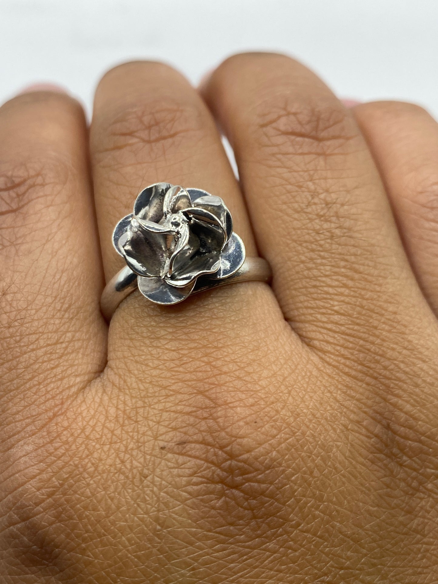 Anillo floral en dedo, mostrando el ajuste natural y el diseño orgánico