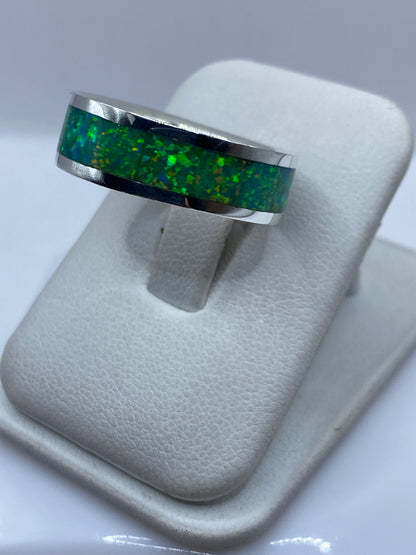 Anillo de ópalo en mano mostrando el brillo verde y los reflejos cambiantes de la piedra