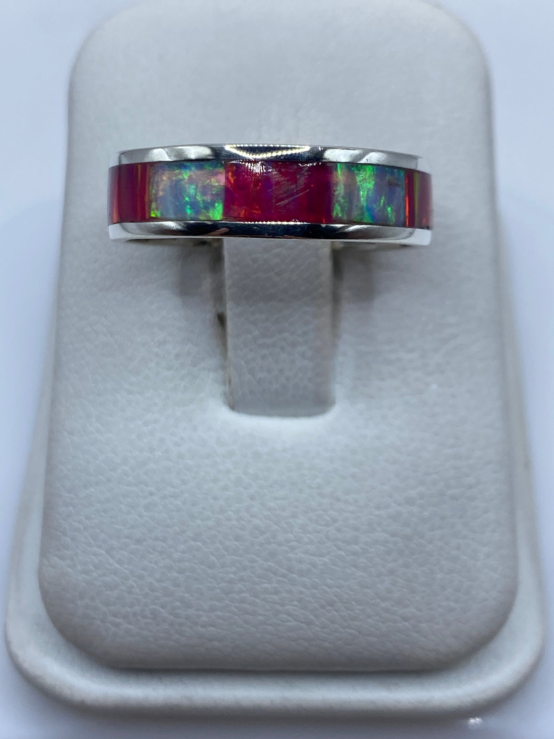 Anillo de plata .950 con ópalo de fuego multicolor en una mano, mostrando los destellos rojo, verde y azul