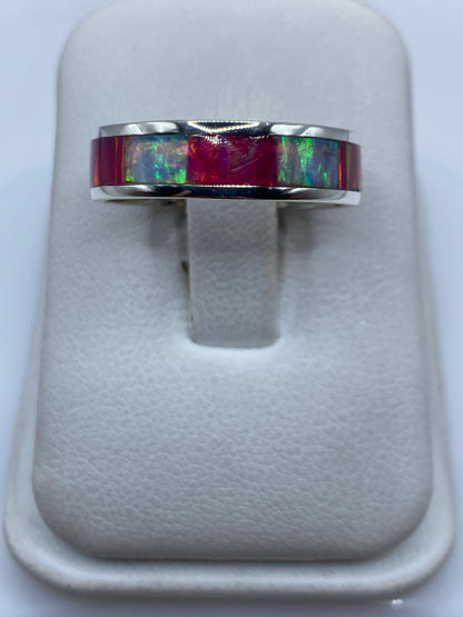 Anillo de plata .950 con ópalo de fuego multicolor en una mano, mostrando los destellos rojo, verde y azul
