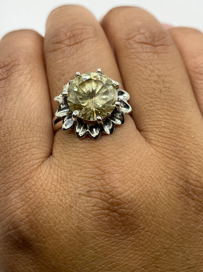 Anillo en la mano mostrando el brillo de la circonia amarillo verdoso bajo la luz
