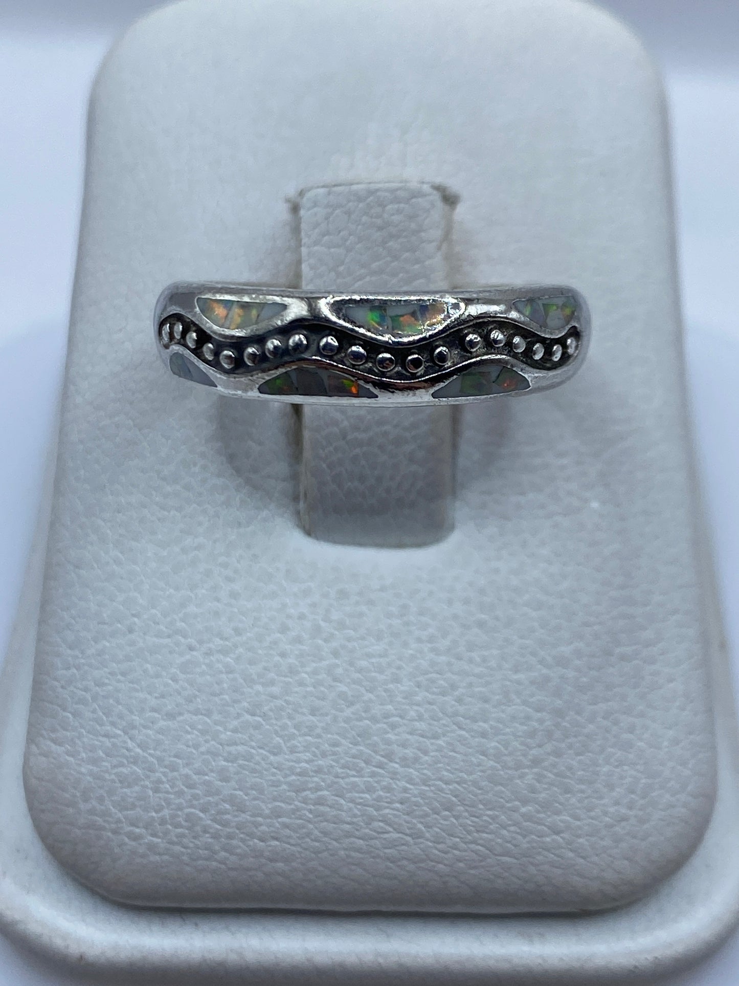 Anillo de plata .950 con ópalo de fuego multicolor en estuche blanco, vista superior del engaste