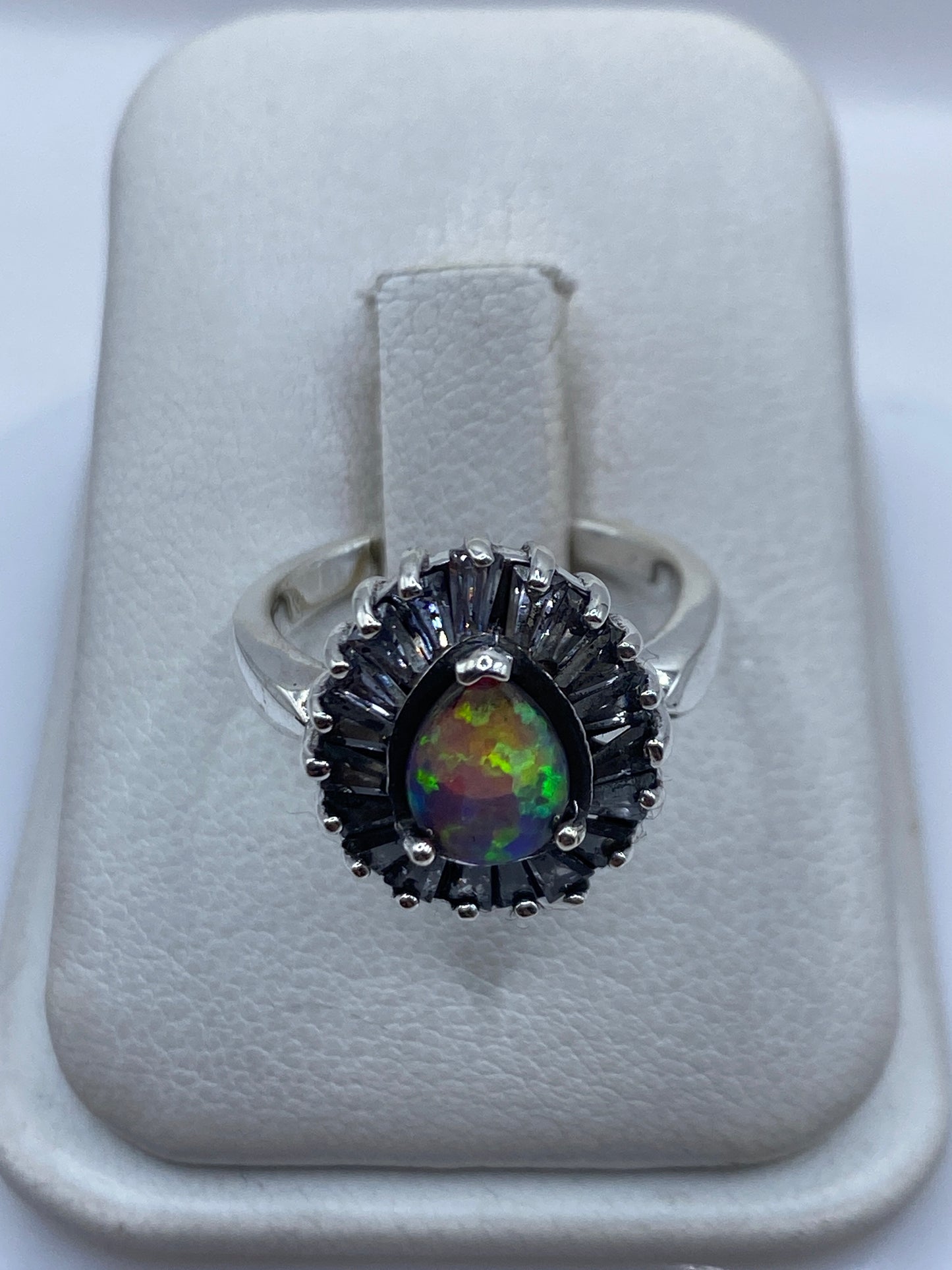 Anillo de plata con ópalo de fuego rosa, centro del enfoque, sobre fondo blanco de presentación