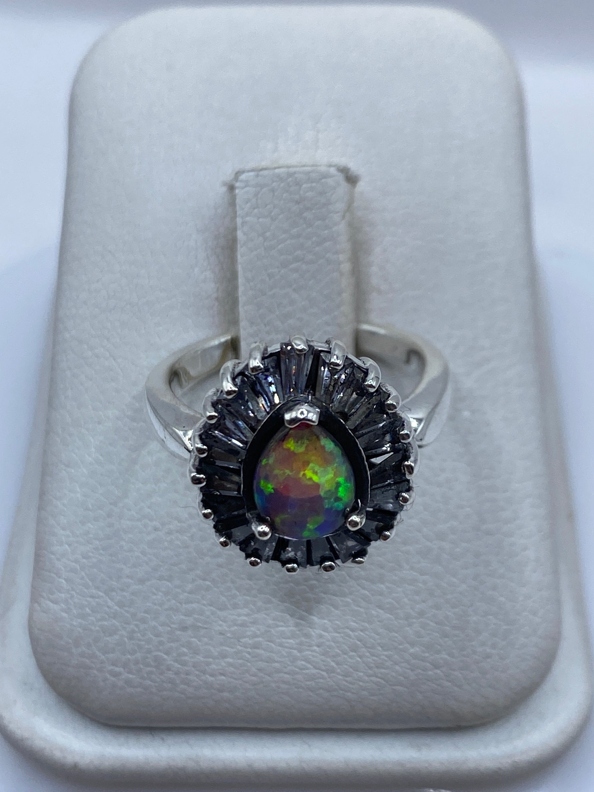 Anillo de plata con ópalo de fuego rosa, centro del enfoque, sobre fondo blanco de presentación