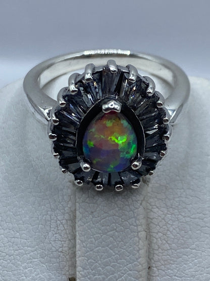 Anillo en dedo mostrando el juego de colores rosa, verde y azul del ópalo de fuego