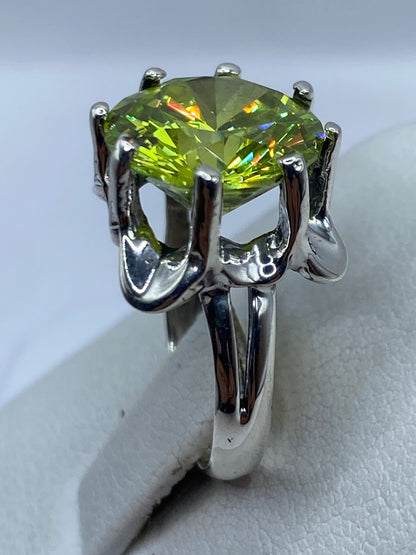 Anillo en la mano mostrando el brillo verde olivo de la circonia