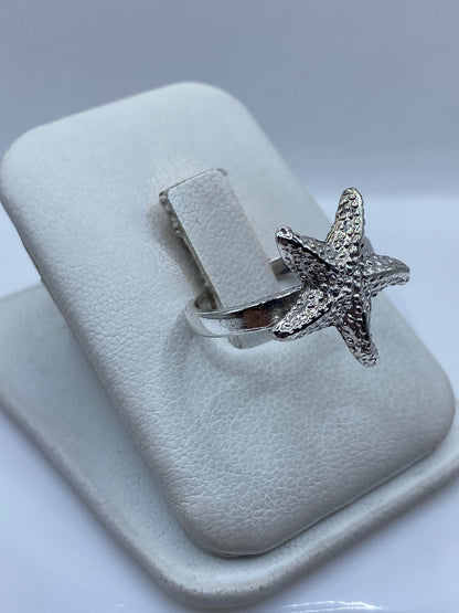 Anillo estrella de mar en plata en la mano, mostrando el brillo y detalle