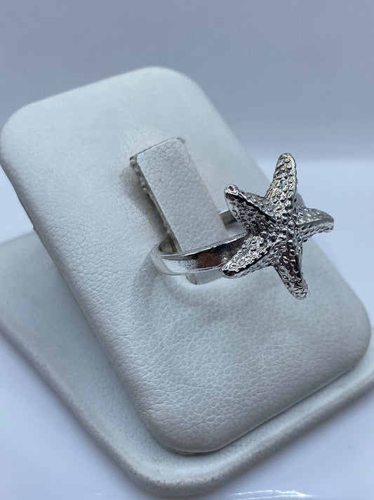 Anillo estrella de mar en plata en la mano, mostrando el brillo y detalle